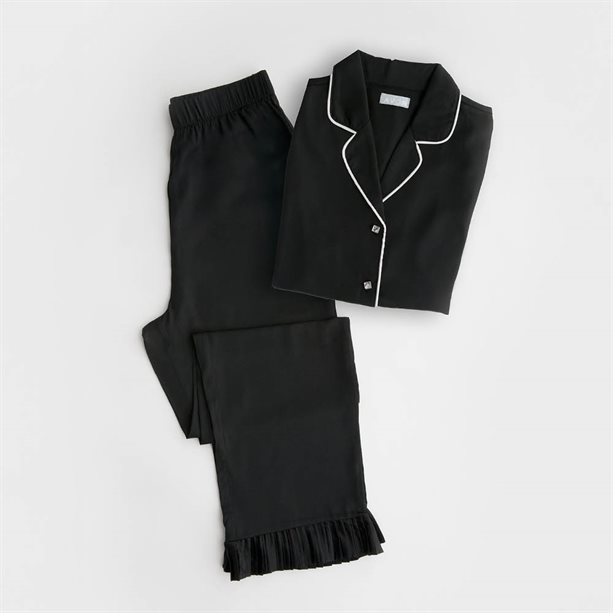 Pigiama da donna in raso nero con volant sull'orlo, profili argentati metallizzati e bottoni effetto pietre preziose, composto da maglia a maniche lunghe e pantaloni a gamba dritta. - 2 | Avon